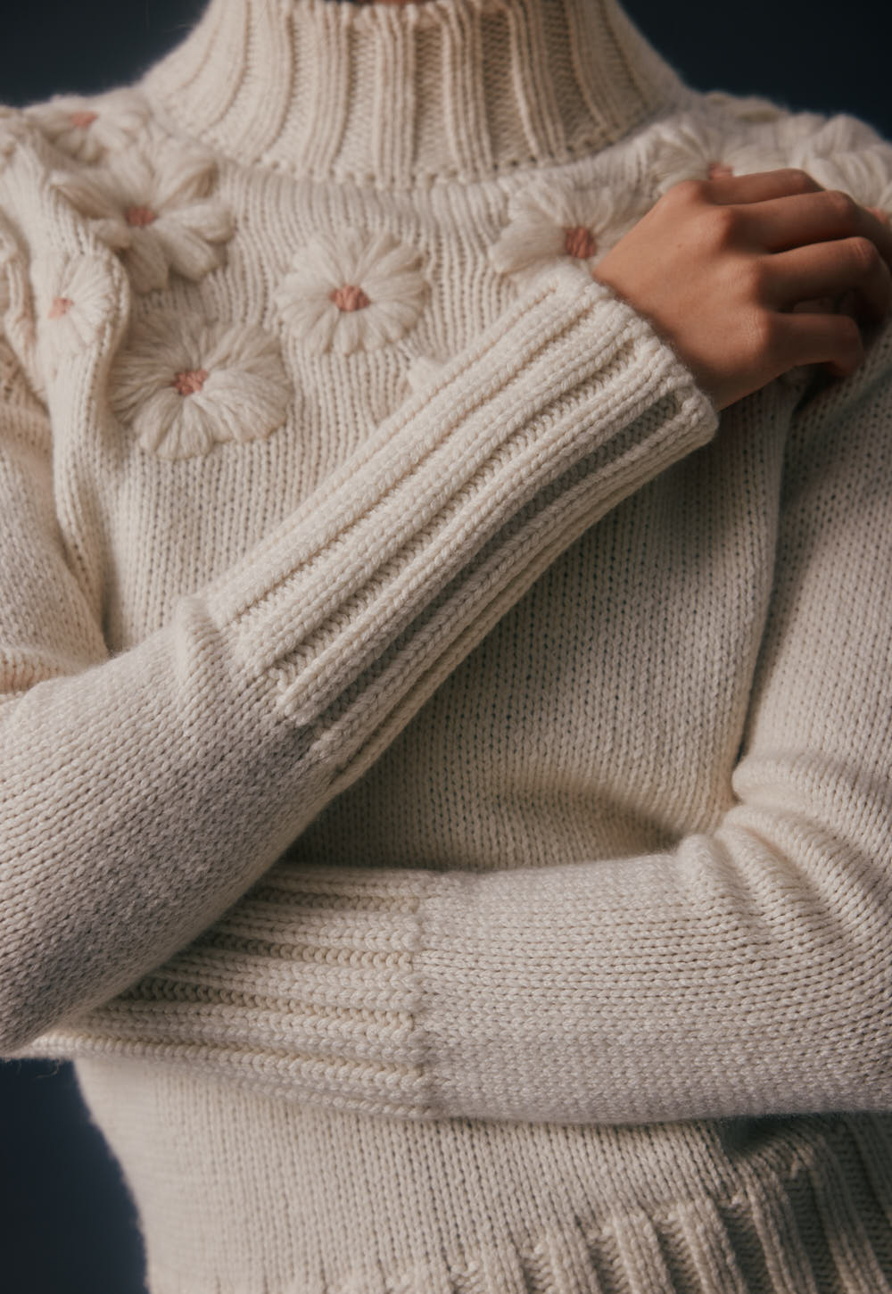 Cashmere sweater sleeve with hand-embroidered flowers, soft knit texture and ribbed cuff