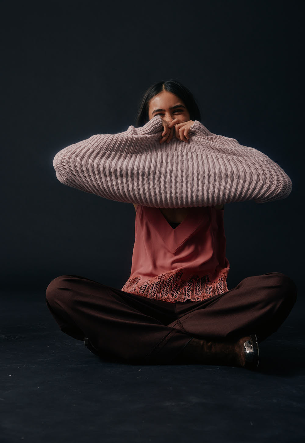 Model wearing the Antonia Zander Udra Top in Dusty Pink layered beneath the Vreni Sweater, with the signature Celestial Lace subtly peeking out at the hem