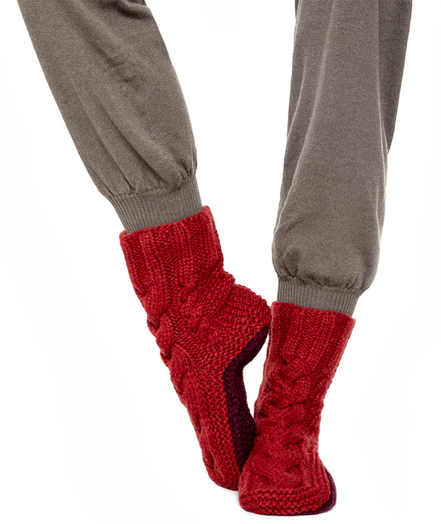 handknitted cashmere houesocks with cableknit details and contrastinc coloured sole